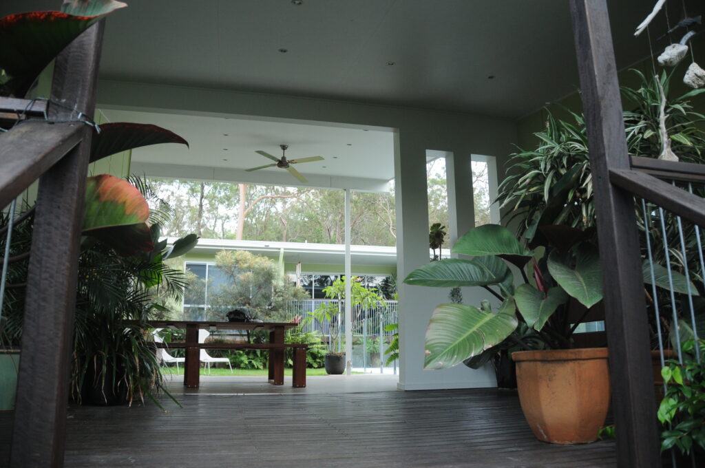 A view to the courtyard of a courtyard house, an open deck dogtrot space with an outdoor fan. Build your own architectural home. Self Build Australia