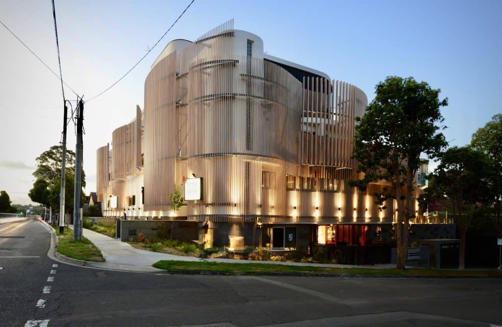 The exterior view of a child care centre, the facade is a nod to the modernist architecture of Corbusier and Alto. Light is filtered through a series of vertical battens screens of varying spacing and cross sectional size.