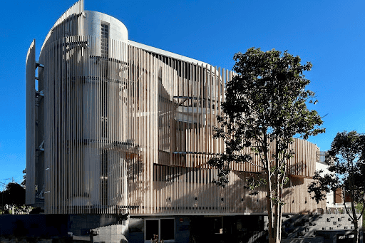 The exterior view of a child care centre, the facade is a nod to the modernist architecture of Corbusier and Alto. Light is filtered through a series of vertical battens screens of varying spacing and cross sectional size.
